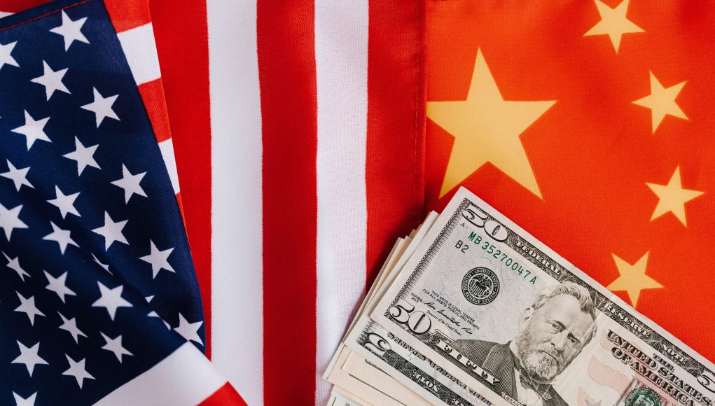 Close-up of US and China flags with US dollar bills